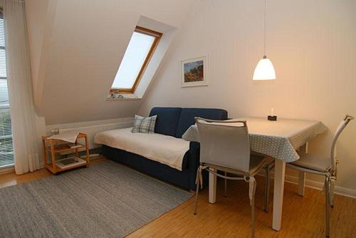 una camera con letto, tavolo e finestra di Ferienwohnung Filter a Hörnum