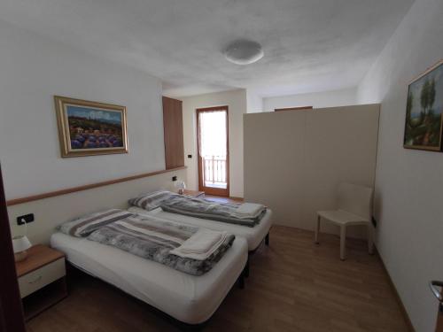 two beds in a room with a window at Residenza Arcobaleno in Tenno