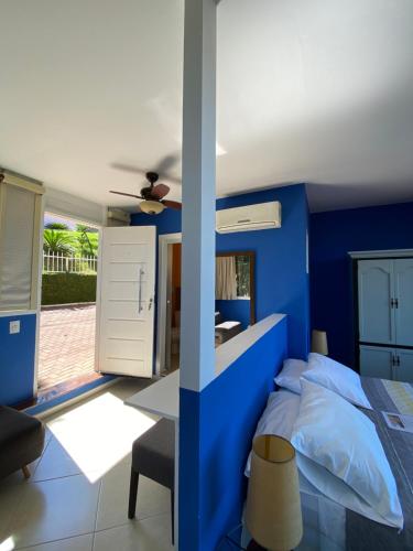 a blue bedroom with a bed and a desk at Top de Buzios Boutique Hotel & Spa in Búzios