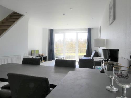 a living room with a table and chairs and a large window at Balade en amoureux au calme in Rochefort