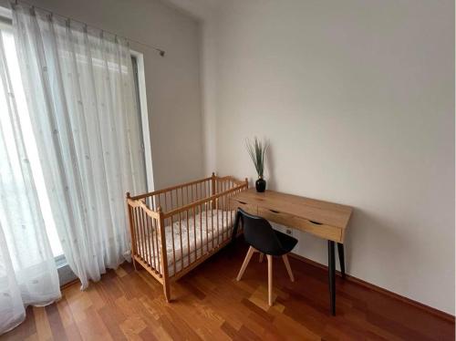 een kamer met een houten bureau en een stoel bij Antresola apartament Zeta Park in Ustroń