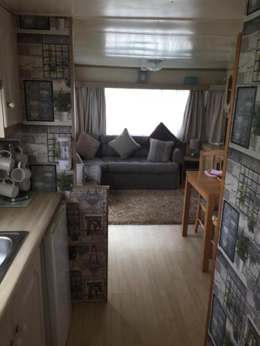 a kitchen and a living room with a couch at L&g caravan hire 4 BERTH CORAL BEACH GEN FAMILYS ONLY AND LEAD PERSON MUST BE OVER 30 in Ingoldmells
