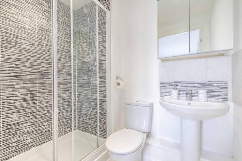 a bathroom with a toilet and a sink and a shower at 2 BED & 2 BATH COSY APARTMENT SLOUGH- FREE PARKING in Slough