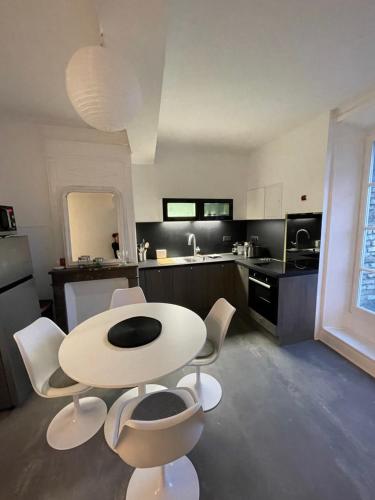 een keuken met een witte tafel en witte stoelen bij Le Quai 7 3e in Dieppe
