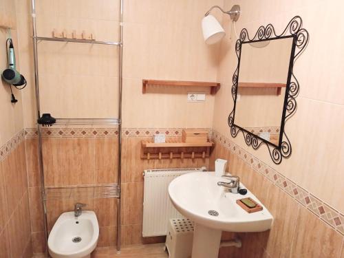 een badkamer met een wastafel, een spiegel en een toilet bij El Duplex Luanquino in Luanco