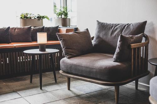 a couch with pillows on it in a living room at Hotel Atlantic in Aarhus