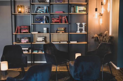 a room with chairs and a book shelf at Hotel Atlantic in Aarhus
