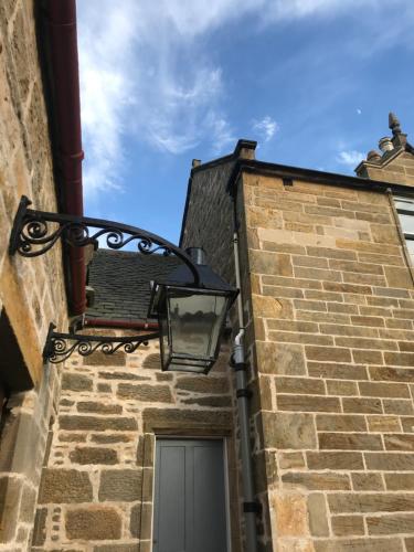 a street light on the side of a brick building at Kilmorie House in Elgin