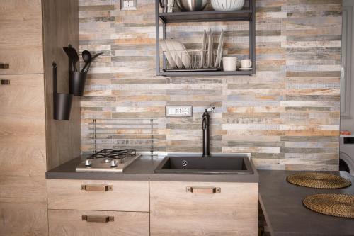 a kitchen with a sink and a brick wall at La Casetta in Quartu SantʼElena