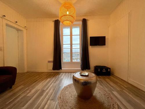 a living room with a large vase on the floor at Le Quai 7 3e in Dieppe