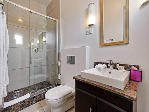 a bathroom with a sink and a toilet and a shower at Ascot Hotel in Johannesburg