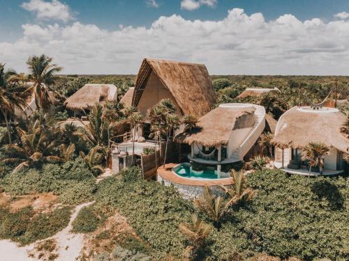 an aerial view of a house with thatched roofs at Papaya Playa Project in Tulum