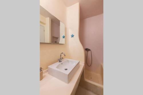 W łazience znajduje się biała umywalka, wanna i lustro. w obiekcie Cycladic Luxury and Comfort in Kalo Livadi w mieście Kalo Livadi