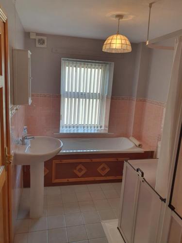 a bathroom with a tub and a sink at Kesh self catering holiday home. in Kesh