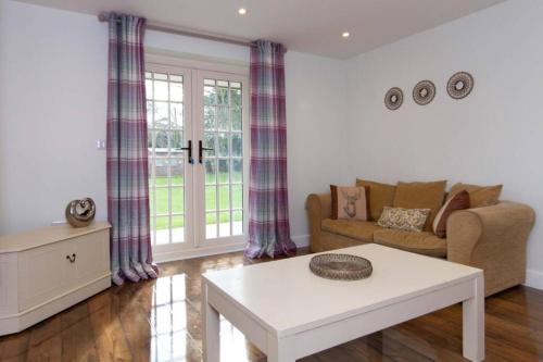 a living room with a couch and a coffee table at Breckland Cottage - Secluded Country Getaway in Hockwold cum Wilton