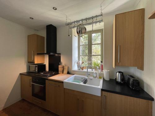 une cuisine avec un évier, une cuisinière et une fenêtre dans l'établissement Riverview, à Bohal