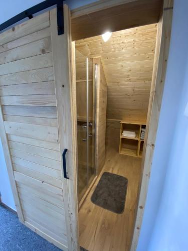 a small wooden sauna with a glass door at UBYTOVÁNÍ S WELLNESS in Dolní Dobrouč