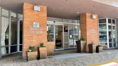 a brick building with potted plants in front of it at Holiday Inn Express Vancouver-Metrotown (Burnaby) in Burnaby