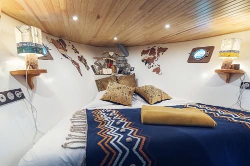 a bedroom with a bed with a blue comforter at Bateau Le Nubian in Narbonne