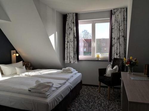 een slaapkamer met een bed, een stoel en een raam bij Die Remise Bayard RE-12 in Stolpe auf Usedom