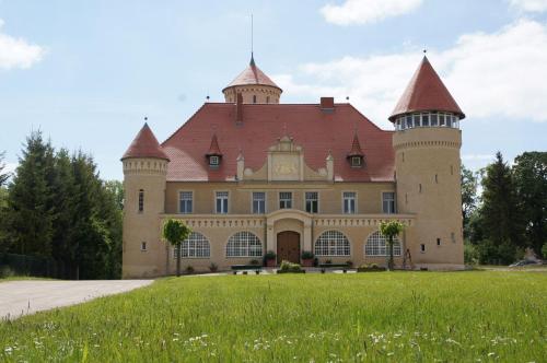 a large castle with a red roof at Die Remise Copenhagen RE-16 in Stolpe auf Usedom