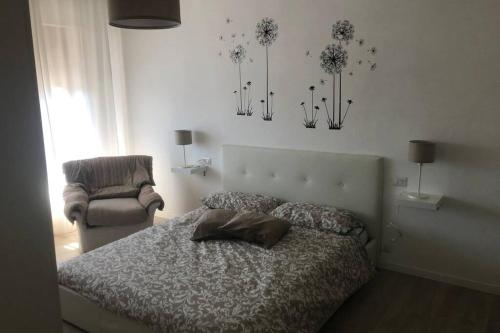 a bedroom with a bed and a chair and lights at Casa Nanda Badia Prataglia in Badia Prataglia