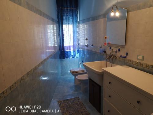 ein Badezimmer mit einem WC, einem Waschbecken und einem Spiegel in der Unterkunft La casa di nicola in Trapani