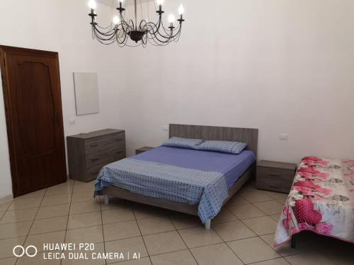 Schlafzimmer mit einem Bett und einem Kronleuchter in der Unterkunft La casa di nicola in Trapani