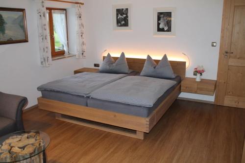 a bedroom with a large bed with blue pillows at Pension Neuhausen in Schönau am Königssee