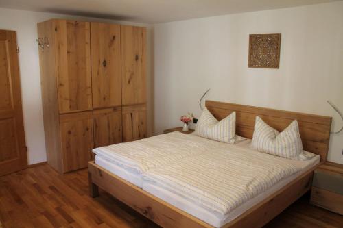 Pension Neuhausen في شونآو أم كونيغزيه: غرفة نوم بسرير كبير وخزانة خشبية
