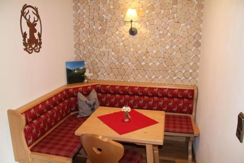 cabina roja con mesa y sofá rojo en Pension Neuhausen, en Schönau am Königssee