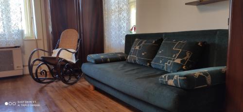 a living room with a green couch and a chair at Teréz Háza in Pázmánd