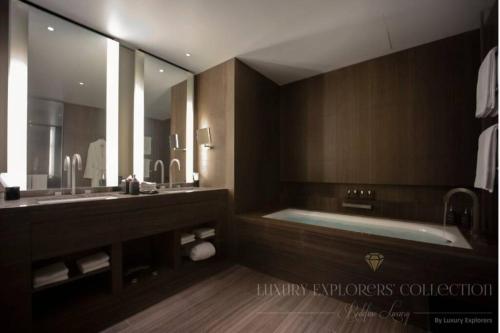 baño con bañera y espejo grande en 1BR Apartment at Armani Hotel Residence by Luxury Explorers Collection, en Dubái