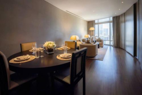 1BR Apartment at Armani Hotel Residence by Luxury Explorers Collection في دبي: غرفة طعام مع طاولة وغرفة معيشة