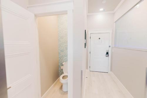a white bathroom with a toilet in a room at River Sirens Hotel-Contactless Check in Hotel in Washington