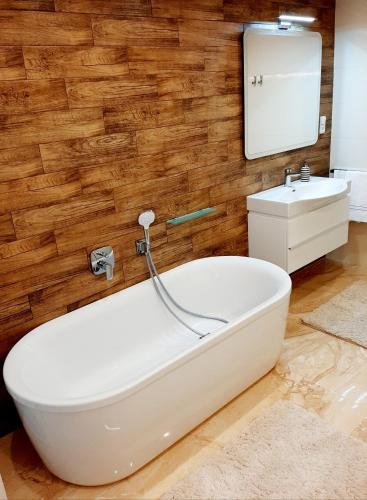 a bathroom with a white tub and a sink at Nobless Apartments Holedná Brno in Brno
