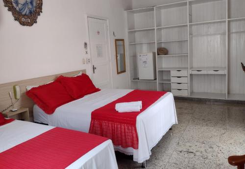 a bedroom with two beds with red and white at Hotel Marajoara in Belém