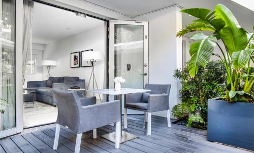 a living room with a table and chairs and a couch at The Sagamore Hotel South Beach in Miami Beach