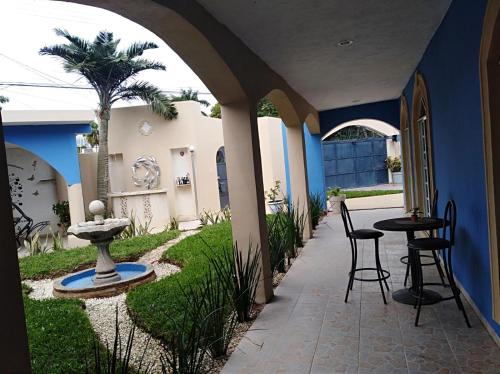a patio with a table and chairs and a palm tree at Serenity Home Hospedaje con confort y seguridad in Mérida