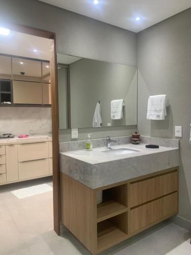um banheiro com uma pia e um espelho grande em Ilê de Pipa Blz em Pipa