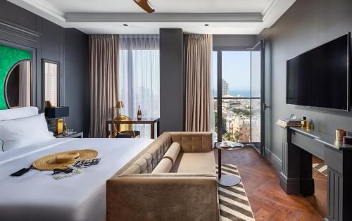 um quarto de hotel com uma cama e um sofá em Debrah Brown, a member of Brown Hotels em Tel Aviv