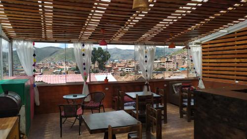 a restaurant with tables and chairs and a view of a city at The Chusay Rooftop in Cusco