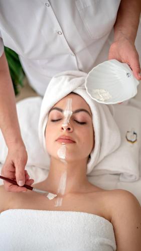 a woman getting her face groomed with a towel at Hotel Costa Galana in Mar del Plata