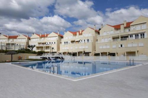 a large apartment building with a large swimming pool at Varandas de Troia in Troia