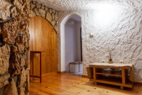 a room with a stone wall and a wooden table at Quinta Forum in Tocha