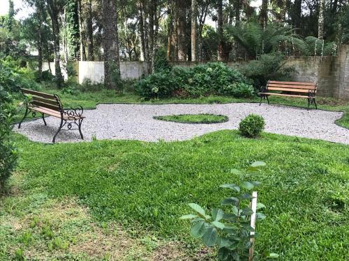 dois bancos sentados num parque com um campo de relva em Piavi Residencial em São Francisco de Paula