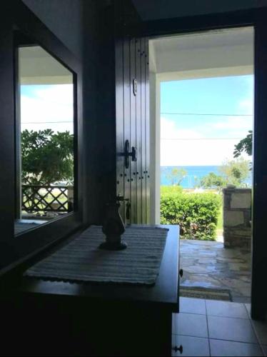 a room with a mirror and a door with a view at Olga Paltsi Rooms in Paltsi Pilion