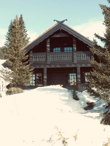 a large log cabin in the snow with trees at Ski and Bike-In and Out in Hafjell