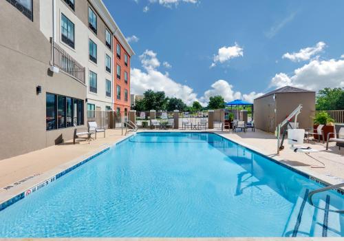 una piscina con sillas y un edificio en Holiday Inn Express & Suites San Antonio NW near SeaWorld, an IHG Hotel, en San Antonio