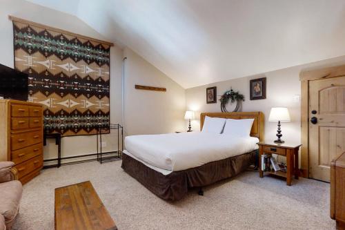 een slaapkamer met een groot wit bed en een bank bij Yampa View in Steamboat Springs